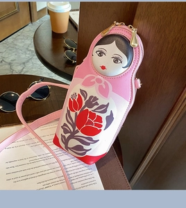 Detail of pink PU Matryoshka crossbody bag with floral tulip print and gold zippers