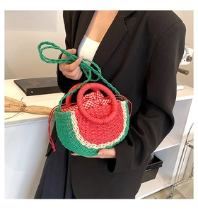 Detail of handmade watermelon straw bag showing woven texture and checkered drawstring liner