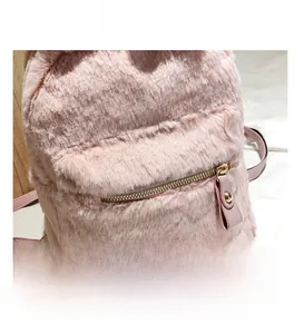 Detailed close-up of pink faux fur texture and gold zipper pocket on rabbit ear backpack