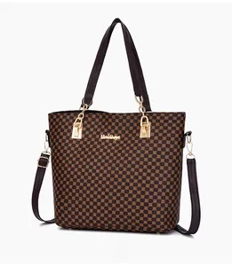 Detail of dark brown leather tote bag featuring vintage circular patterns and gold hardware