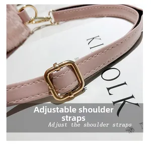 Detail of pink faux leather adjustable shoulder strap with gold metal buckle on plush bag