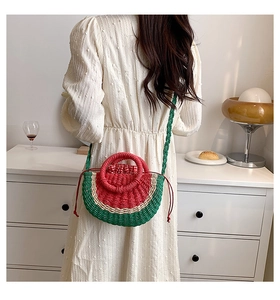 Detail of a watermelon shaped straw bag with tricolor woven texture and drawstring liner