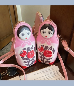 Detail of pink Russian nesting doll crossbody bag with floral patterns and gold zipper