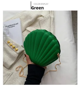 Detail of shell-shaped crossbody bag in lime green lychee leather with gold chain strap