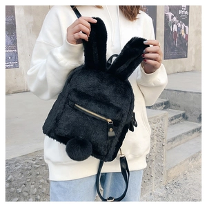 Close-up of black plush bunny backpack featuring long fuzzy ears and a pom-pom tail