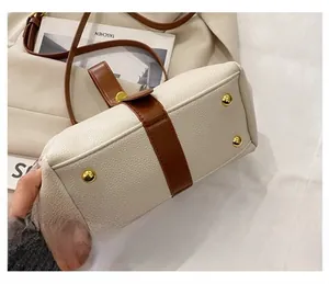 Detail view of the shell bag bottom with four golden protective studs and pebble leather