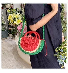 Detail of watermelon straw bag with red drawstring lining and green woven strap