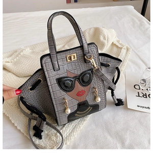 Detail of grey crocodile pattern handbag with cartoon character and 3D pearl earrings