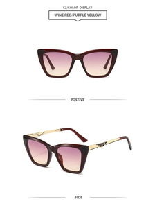 Detail of wine red cat-eye sunglasses with gradient lenses and gold geometric temples