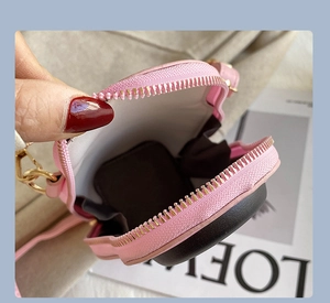 Detailed interior of heart-shaped pink leather crossbody bag with golden metal zipper