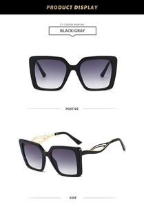 Detail of square sunglasses with black frame, gray lenses and golden hollow temples