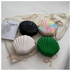Detail of shell-shaped crossbody bags in leather with gold chain and pearl charms