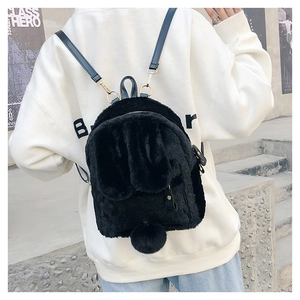 Detail of cute black faux fur backpack with rabbit ears and a soft plush pompom