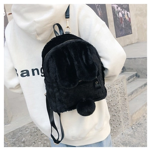 Detail view of the black fuzzy bunny ear backpack showing soft plush texture and straps
