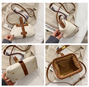 Detail view of cream shell bag showing metal base studs and brown leather interior lining