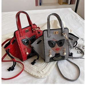 Detail view of crocodile pattern wing tote bags with portrait motifs and pearl earrings