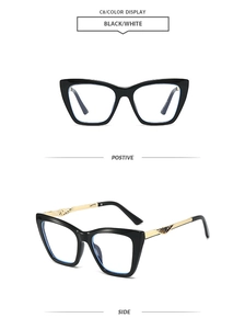 Detail of cat-eye sunglasses with gold wing-shaped carving on black temples