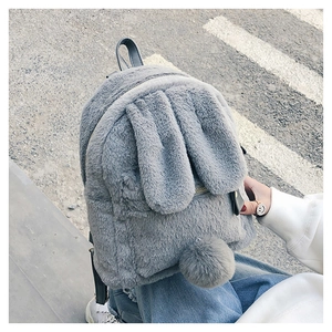 Detail of grey faux fur backpack with cute rabbit ears, plush tail, and zip closure