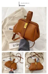 Close-up of brown litchi pattern shell bag featuring a gold metal lock and leather handle