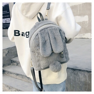Detail showing plush rabbit ears and a fluffy tail on a soft grey fleece backpack