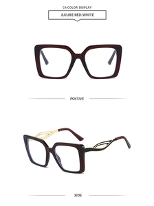 Detail view of square frame jujube red sunglasses with gold filigree metal temples