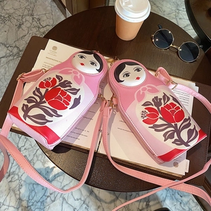 Detail view of pink Russian nesting doll crossbody bags made of smooth PU leather