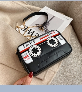 Detail of vintage cassette tape crossbody bag with metal zipper and golden chain strap