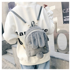 Detail of grey plush rabbit backpack featuring soft bunny ears and fluffy pom-pom tail