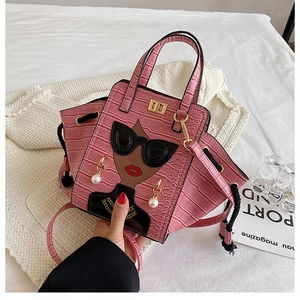 Detailed view of pink crocodile-embossed bag with creative embroidered female portrait decoration