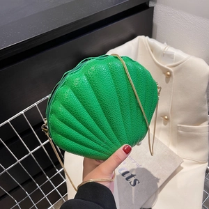 Vibrant green shell-shaped crossbody bag with gold chain strap and snake texture