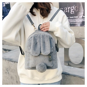 Close-up of cute grey plush rabbit backpack with long ears and fluffy tail details