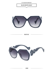 Detail view of blue and white oversized hexagonal sunglasses with cut-out temples