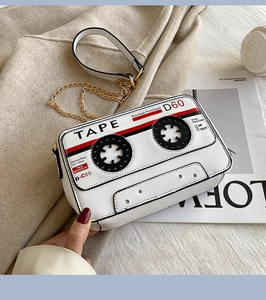 Detail of white retro cassette tape crossbody bag with gold chain and cutout reels
