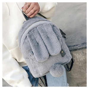 Detail of plush grey faux fur backpack featuring cute long bunny ears and a soft pom-pom tail
