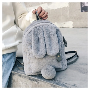 Detail of gray plush backpack featuring long rabbit ears and soft faux fur texture