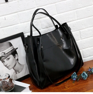 Detalle del bolso tote negro de cuero PU con tachuelas metálicas y correa larga ajustable