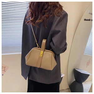 Close-up of khaki retro shell bag showing a stylish gold clasp and lychee leather texture