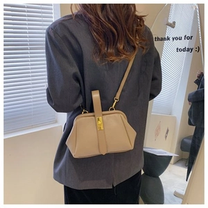 Beige faux leather clasp shell bag shown on model highlighting elegant size and fit