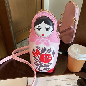 Detail of pink Russian doll PU crossbody bag with floral pattern and golden metal zipper