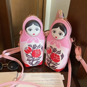 Detail of pink Russian doll PU leather crossbody bags with golden metal zippers and floral patterns