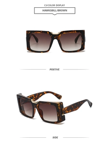 Detail view of square tortoiseshell sunglasses with brown lenses and gold metal bridge
