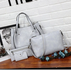 Detalle de juego de cuatro bolsos grises de cuero PU con bolso tote y bandolera