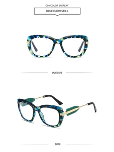 Macro detail of cat-eye glasses with blue tortoiseshell frame and gold metal hinges