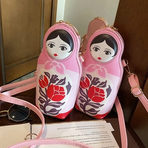 Close-up of creative pink Matryoshka PU crossbody bag with floral prints and gold zipper