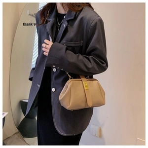 Chic beige matte leather shell bag with gold lock buckle styled on a grey blazer