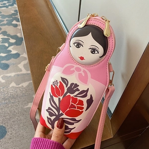 Detail of pink PU leather Matryoshka crossbody bag with floral pattern and gold zippers
