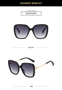 Detail view of square black frames with gold metal temples and dark gray gradient lenses