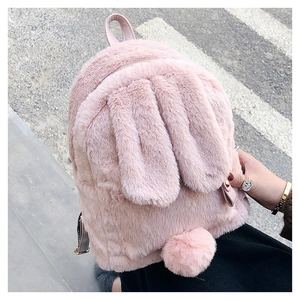 Detailed view of pink plush rabbit backpack with long ears and fuzzy pompom tail