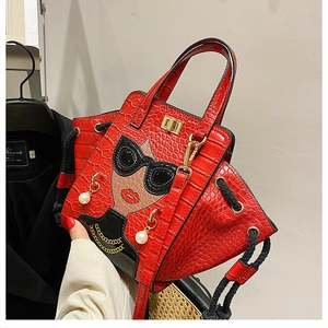 Detail of red croc-effect handbag featuring a cartoon girl with pearl earrings and chain