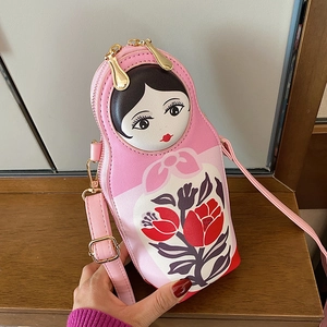Pink Russian nesting doll crossbody bag with floral patterns and a long shoulder strap